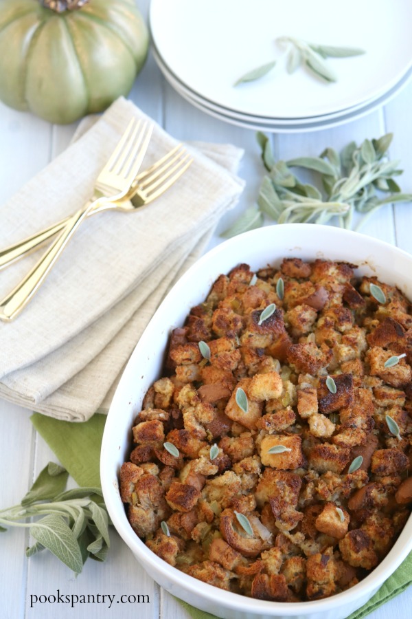 bread stuffing in white casserole dish with sage leaves
