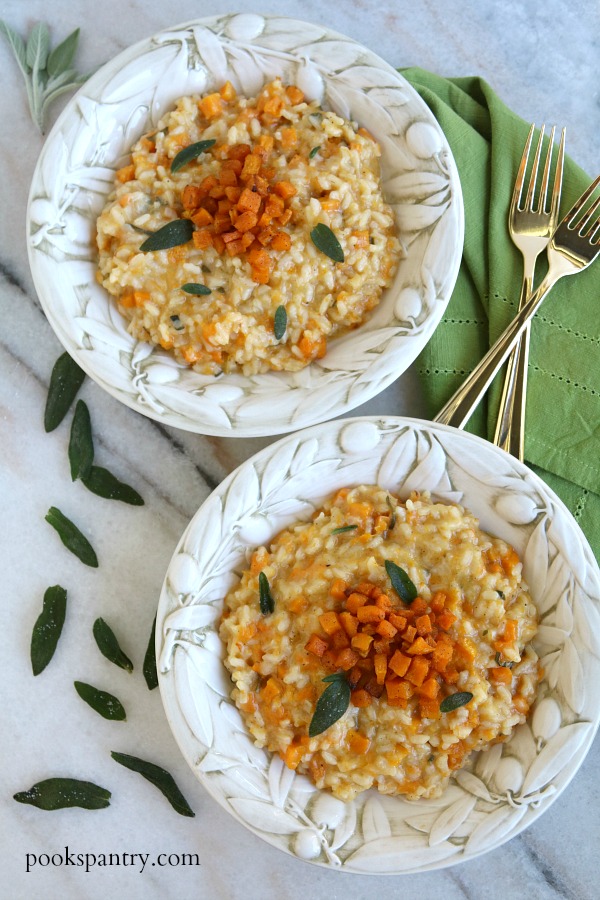 two bowls of butternut squash risotto with gold forks