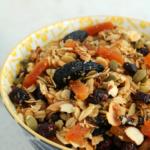 fruit and nut granola in blue and yellow bowl on marble counter
