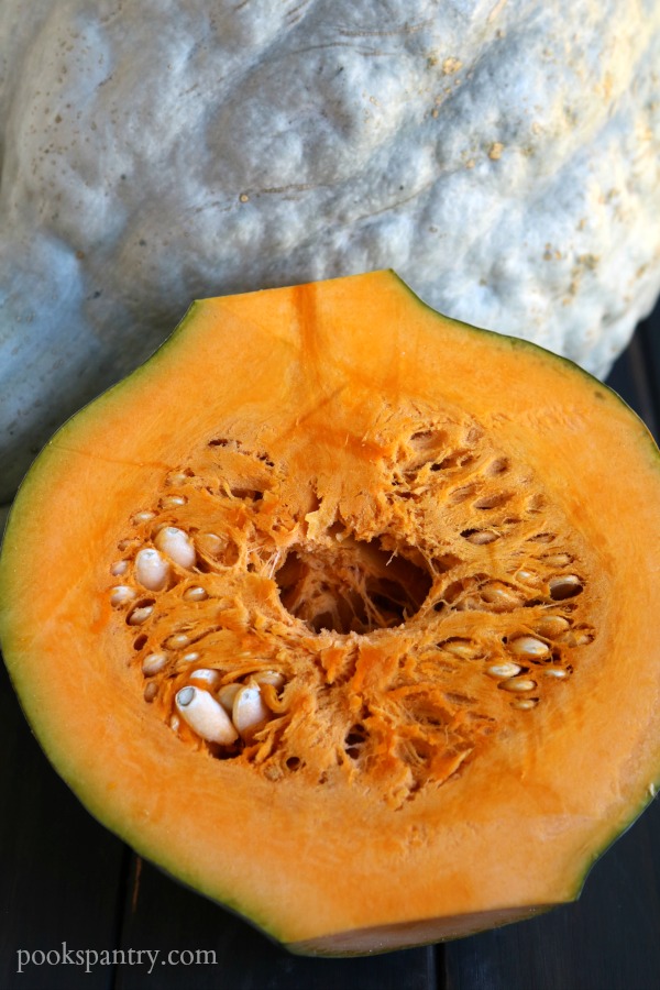 Inside of squash with seeds on wooden background.