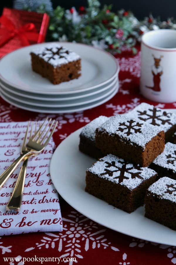 gingerbread cake recipe on platter with stacked plates in background