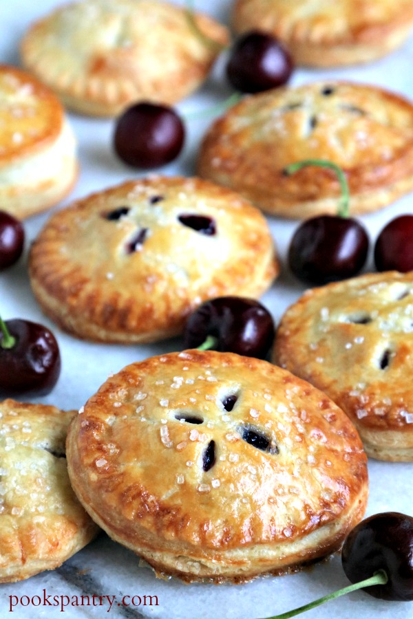 cherry hand pies with cherries on marble board