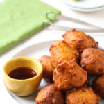 corn fritters on white plate with spicy honey