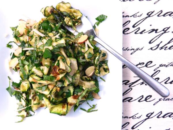 zucchini salad on white plate with fork