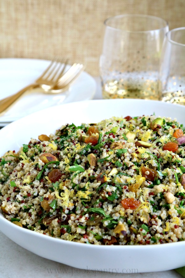 Quinoa salad in bowl with gold forks in background.