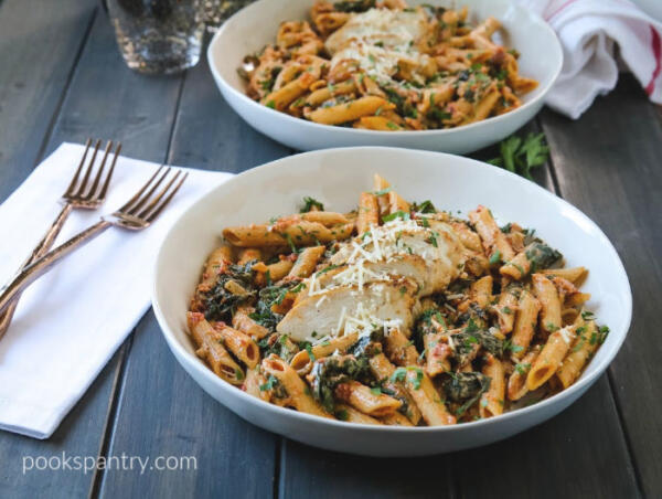 bowls of chicken pasta with spinach and sun-dried tomato cream sauce