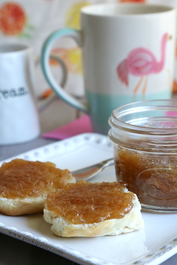 Biscuits on plate with jam and jar.