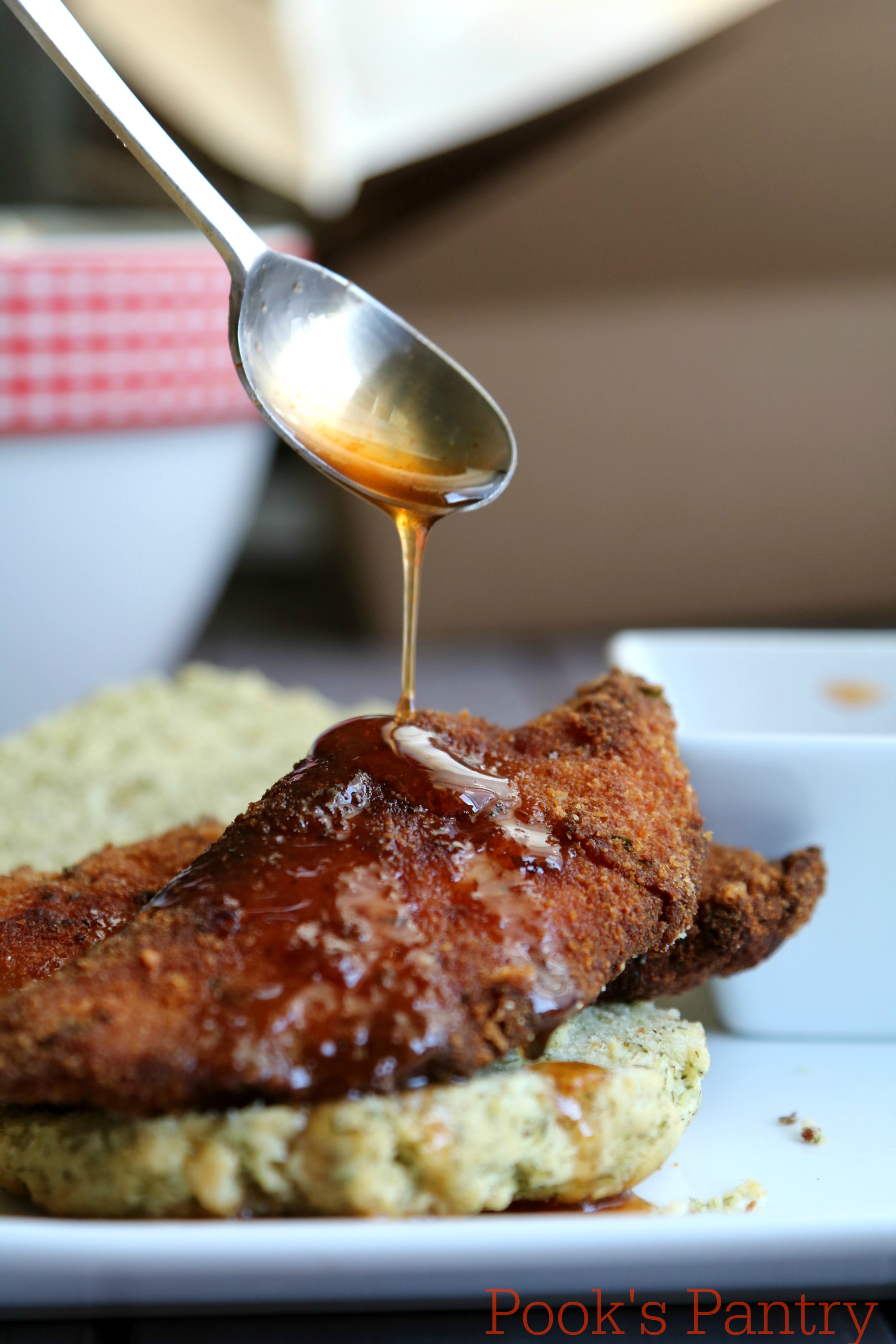 honey drizzling off spoon onto chicken finger