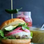 Pork burger with hatch chili on a wooden block.