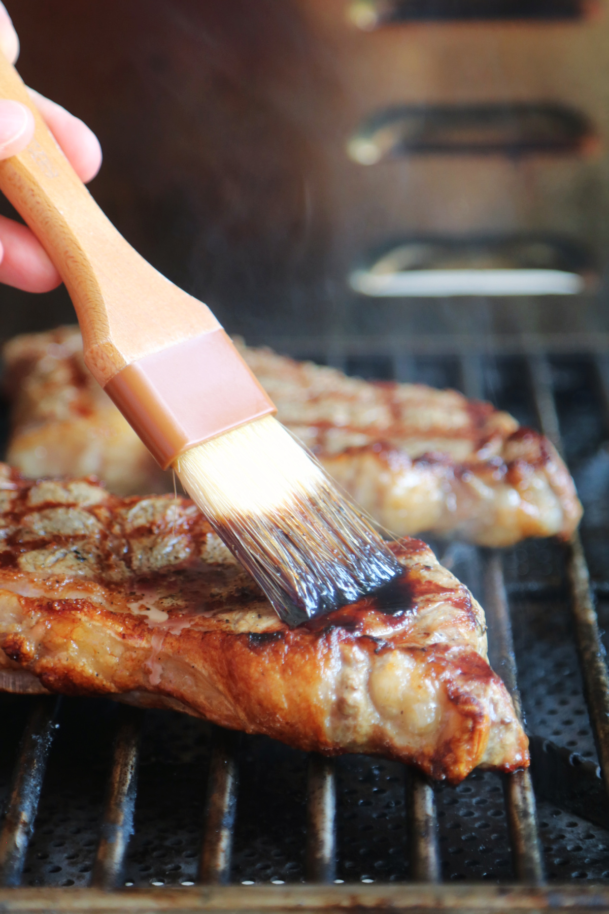 Basting steak on the grill.