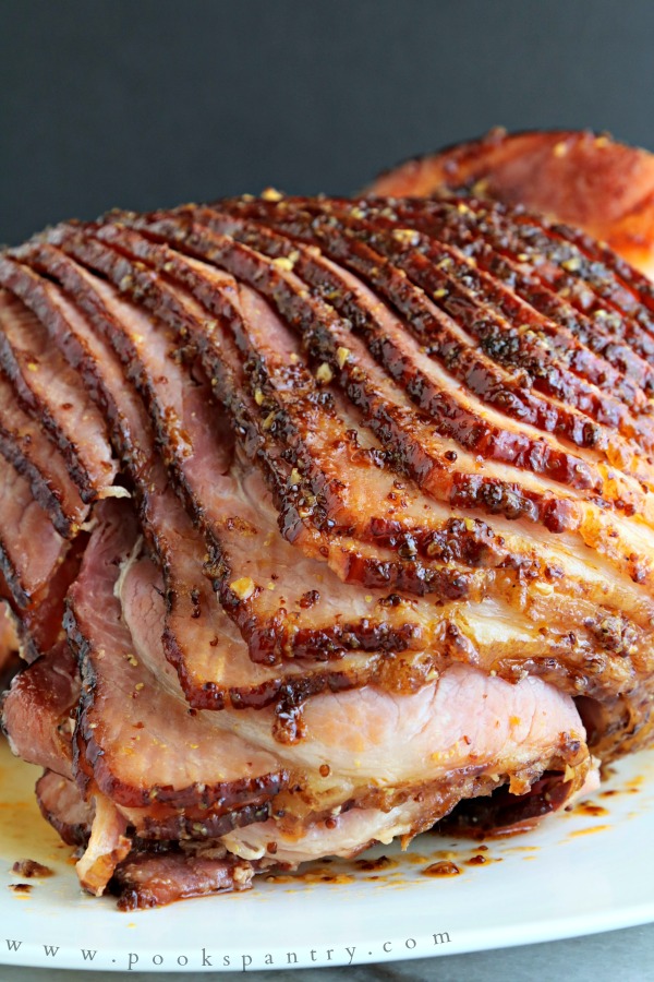 Sliced, glazed ham on a white platter.