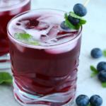 blueberry spritzer in glass with mint and blueberry garnish