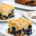 Slices of blueberry crumb cake on china plates.