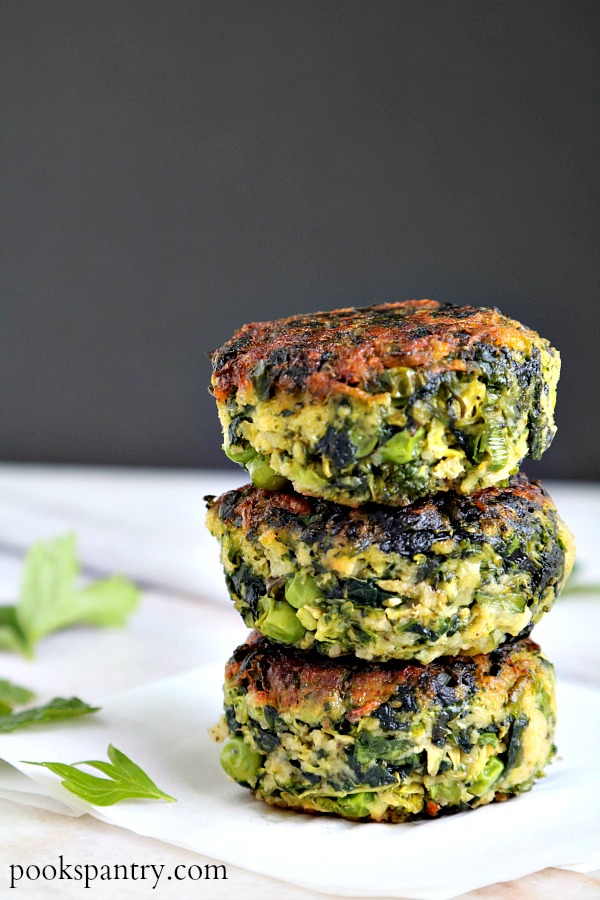 green vegetable cakes stacked on paper with herbs