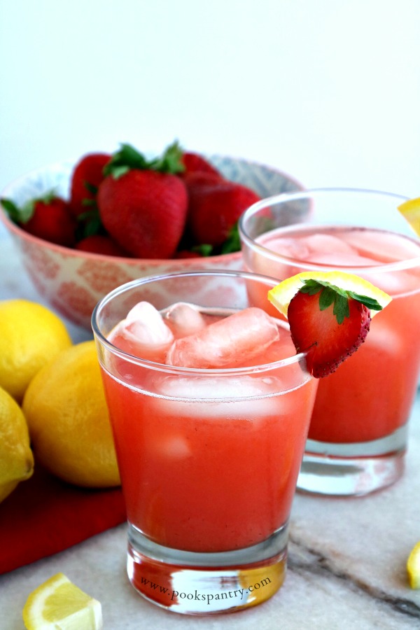 lemonade in glasses with bowl of strawberries