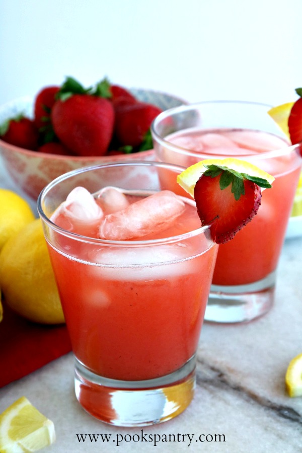 strawberry lemonade in clear glasses with sliced strawberry garnish