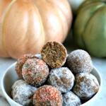 pumpkin rum balls in white bowl with pumpkin decorations in background