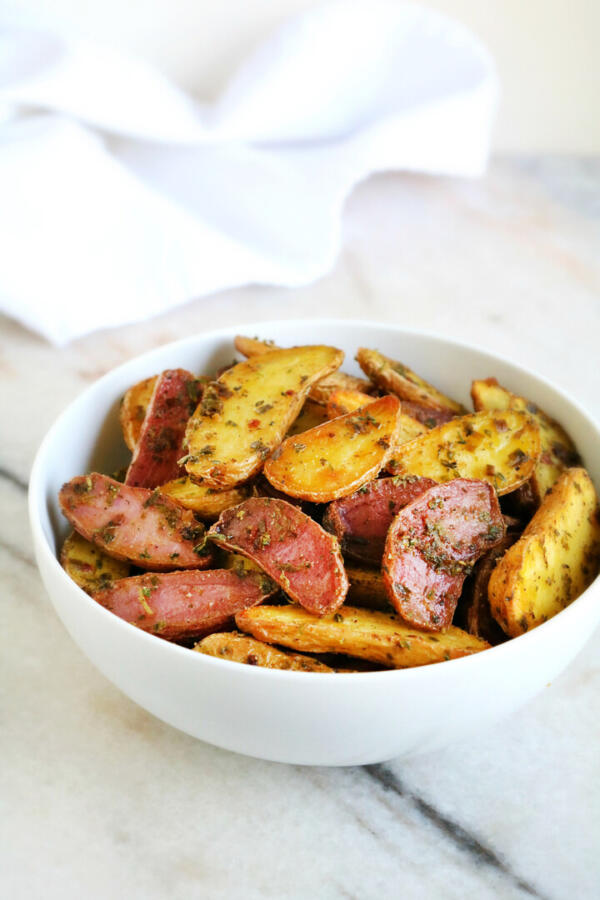 roasted fingerling potatoes in white bowl with white napkin