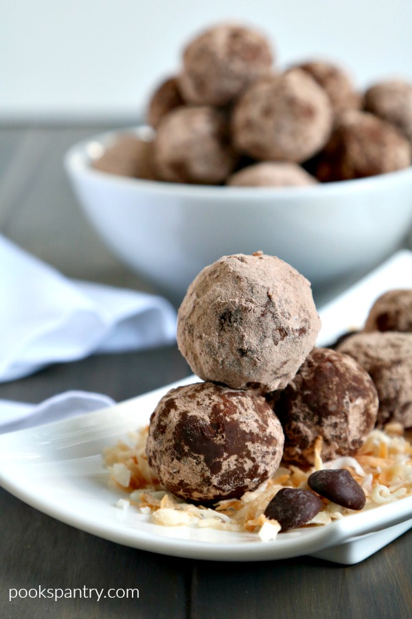stacked chocolate coconut rum balls on white plate