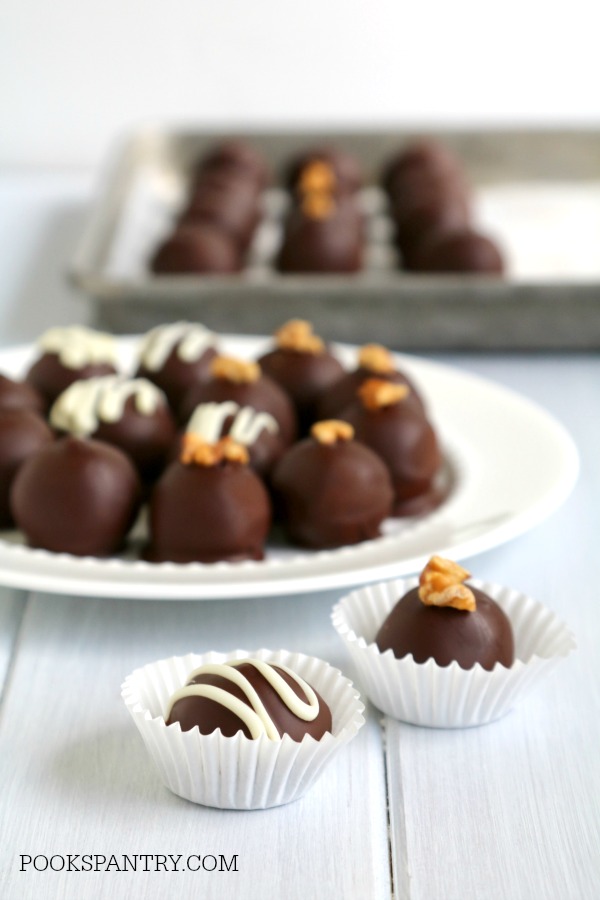 chocolate covered rum balls with white chocolate drizzle