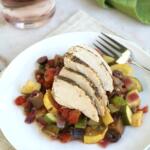mediterranean chicken and vegetables on white plate with fork