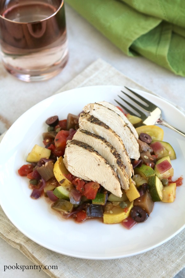 mediterranean chicken and vegetables on white plate with fork