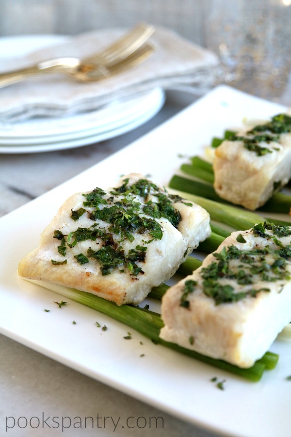 corvina with butter and herbs on white platter