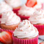 Frosted strawberry cream cheese cupcake on marble board.