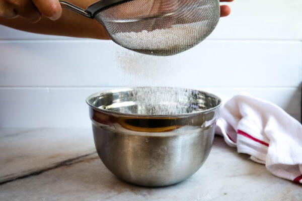 sifting dry ingredients into a bowl