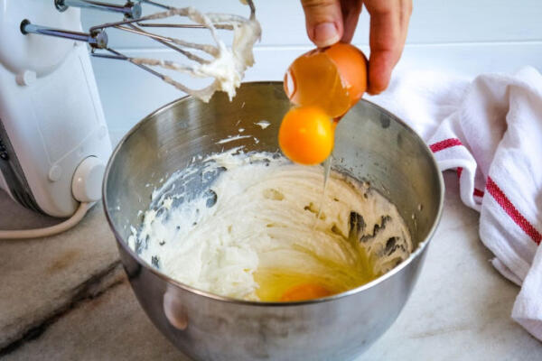 adding eggs to batter in bowl