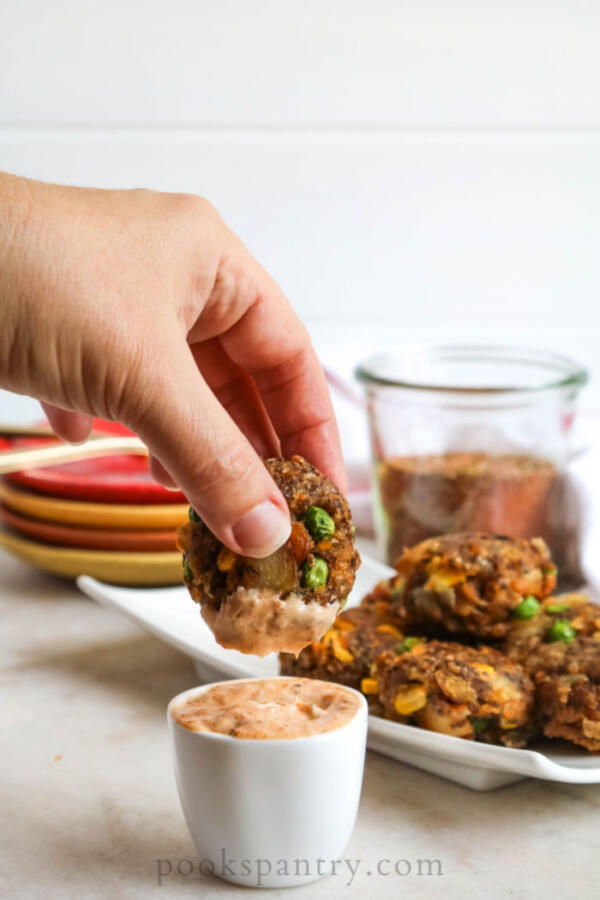 dipping vegetable cakes in sauce