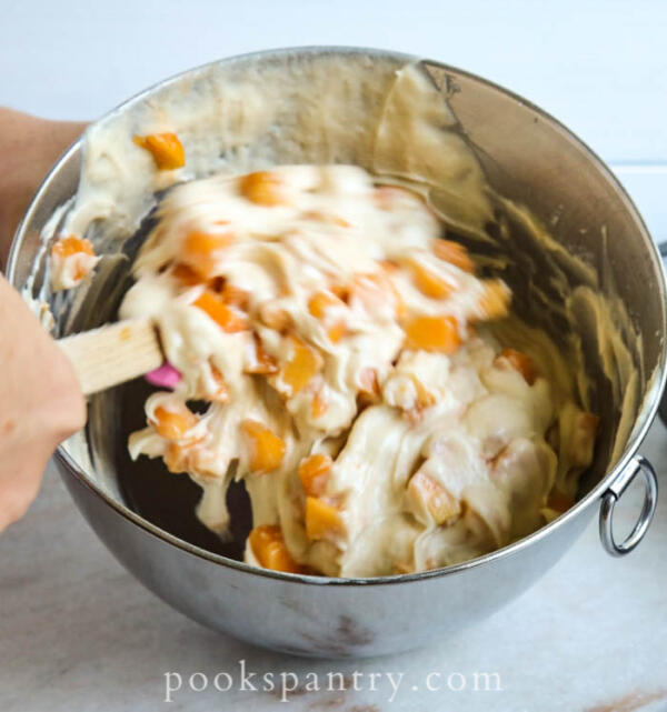 stirring peaches into muffin batter
