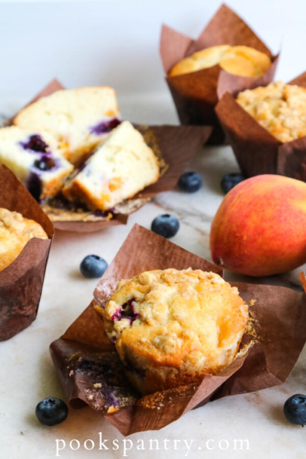blueberry peach muffins in brown muffin papers