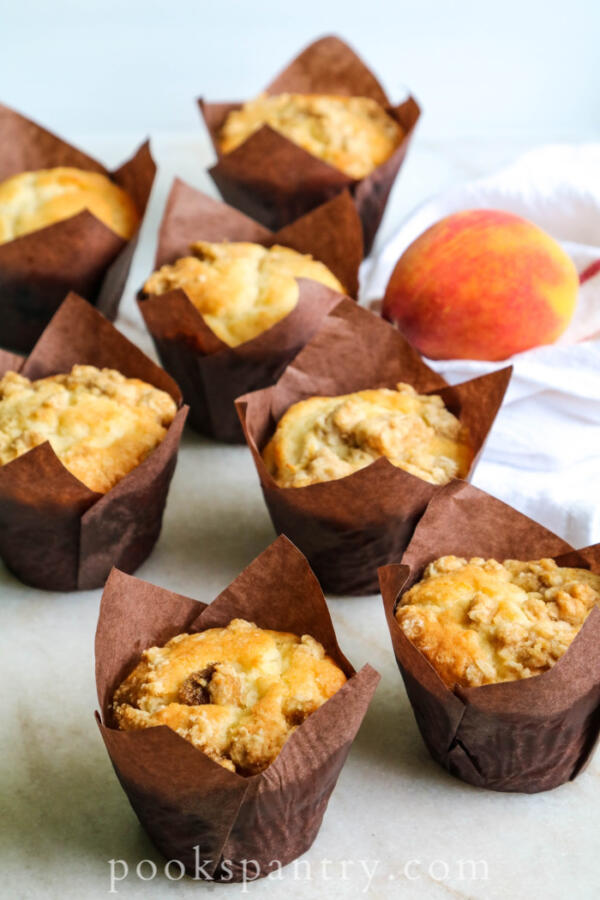 peach crumble muffins in brown paper liners