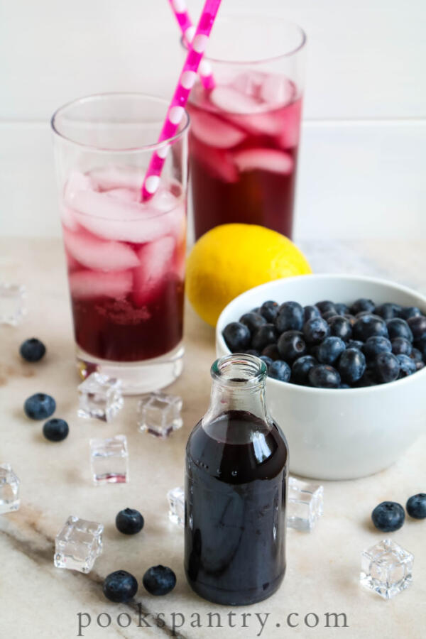 blueberry syrup for drinks in small bottle with blueberries in background