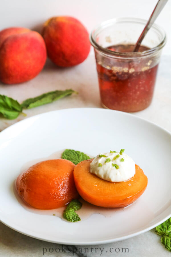 bourbon peaches with mint and vanilla syrup on white plate