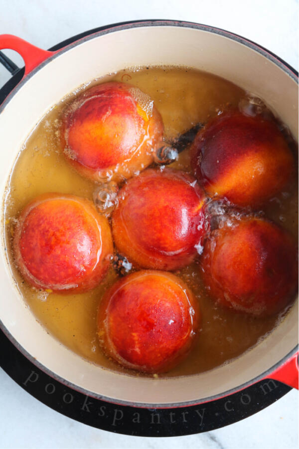 simmering peaches in large pot with vanilla.
