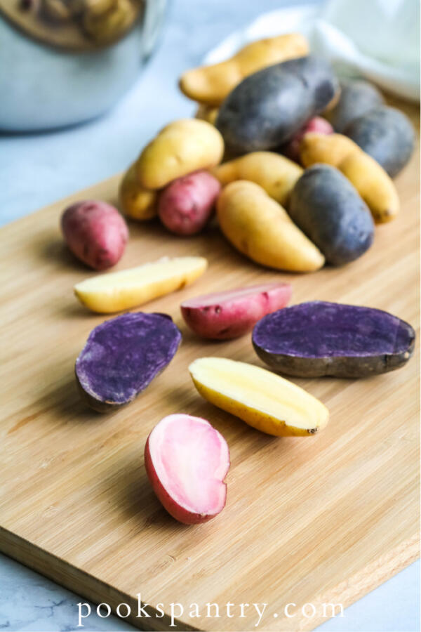 Multicolored fingerling potatoes on cutting board.