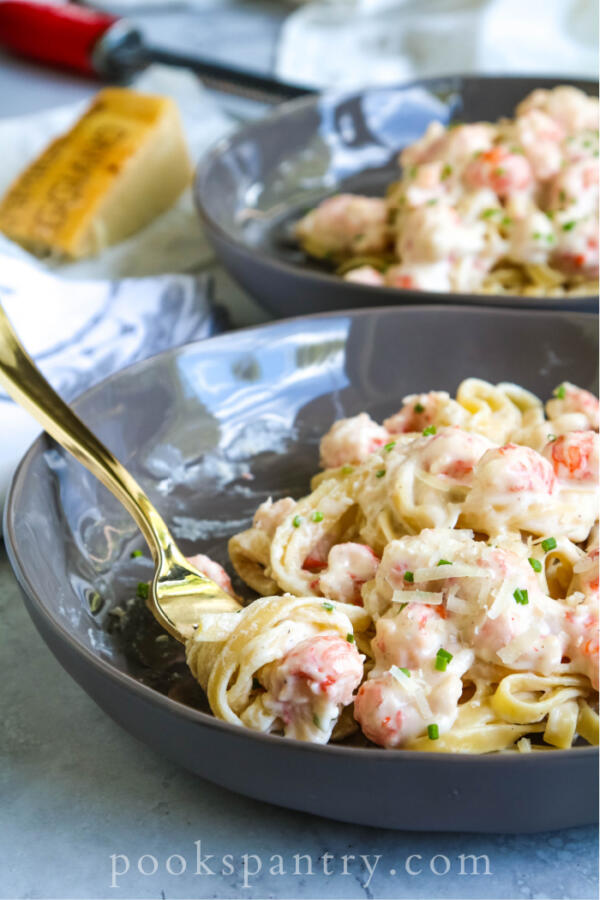 langostino pasta on gold fork with chives and cheese
