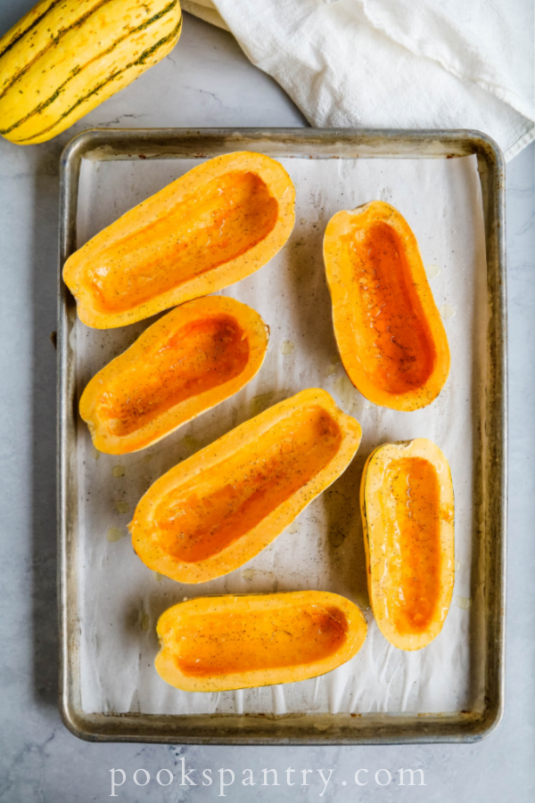 Cleaned squash halves on parchment lined sheet pan.