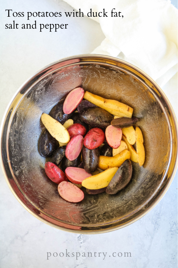 tossing purple, red and yellow fingerling potatoes with seasonings in bowl.
