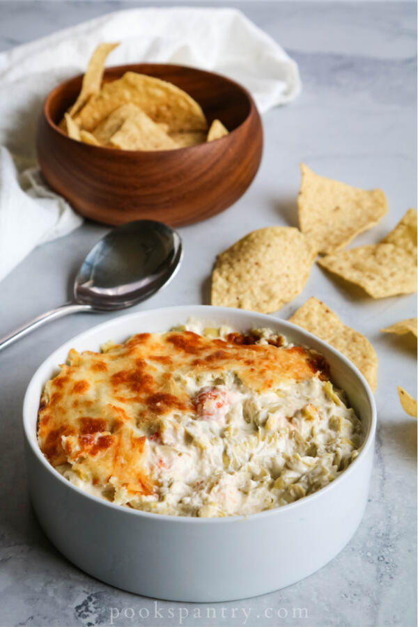 langostino artichoke seafood dip with chips and spoon