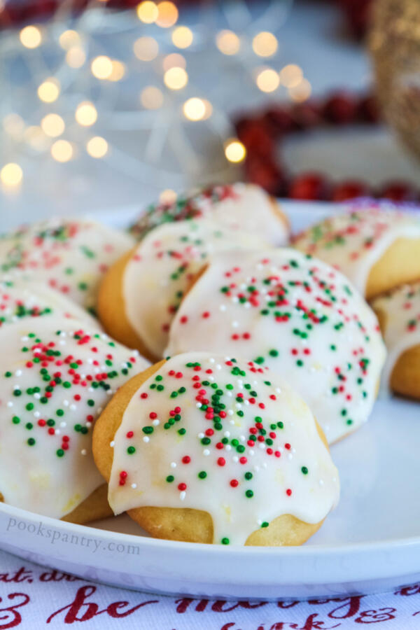 Lemon ricotta cookies with sprinkles on white plate with lights in background.