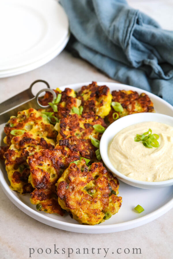 plated curried cauliflower cakes with scallions
