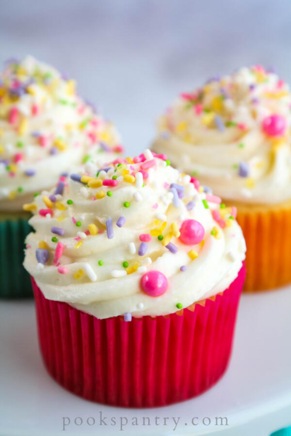 cream cheese cupcakes with cream cheese frosting covered in sprinkles