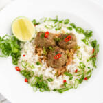 Thai turkey meatballs with green curry, ginger, and lime in a white bowl with a wide rim.