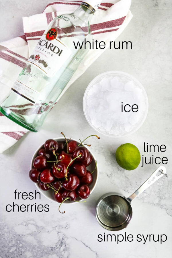 Ingredients for cherry daiquiri on gray marble background.