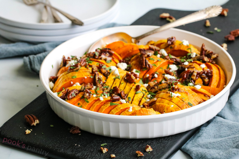 Roasted Honey squash in white casserole dish with maple pecans and goat cheese.