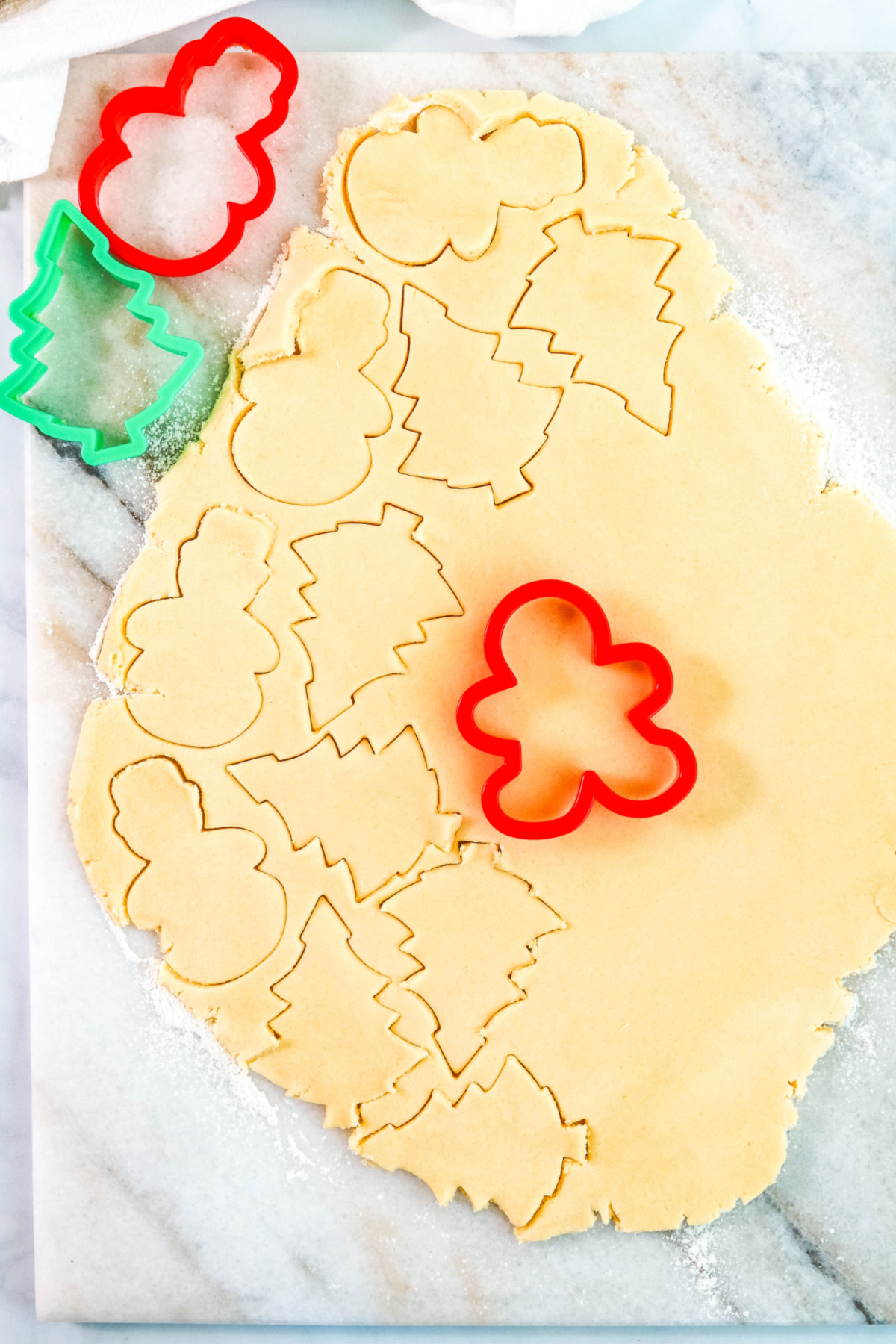 Cutting out sugar cookies on a marble slab.