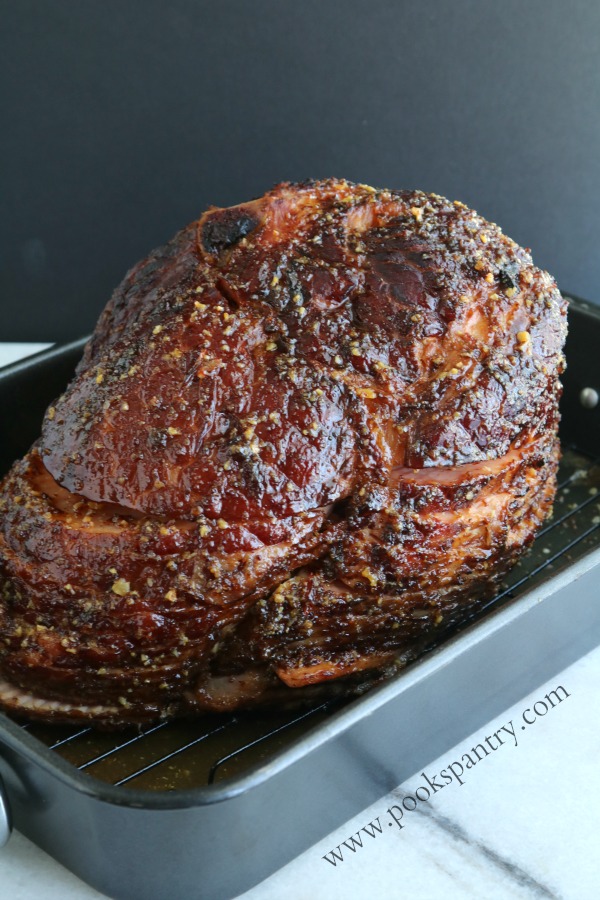Spiral ham glazed with honey mustard and chipotle in roasting pan.